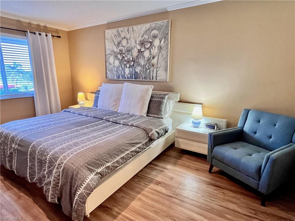 256 Palm Drive, Unit 6 Naples, FL 34112 - Photo 8 of 27 a large bedroom with a bed and wooden floor