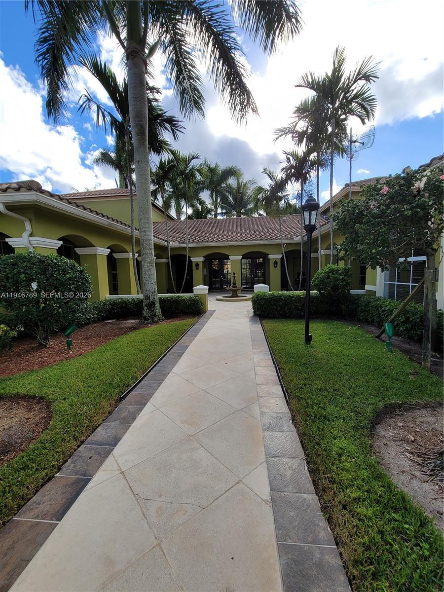 2090 West Preserve Way, Unit 301 Miramar, FL 33025 - Photo 19 of 21 a view of a house with a yard and palm trees