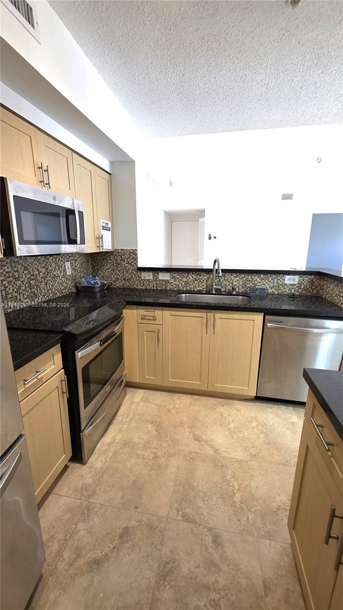 2090 West Preserve Way, Unit 301 Miramar, FL 33025 - Photo 2 of 21 a kitchen with stainless steel appliances granite countertop a stove a sink and a microwave