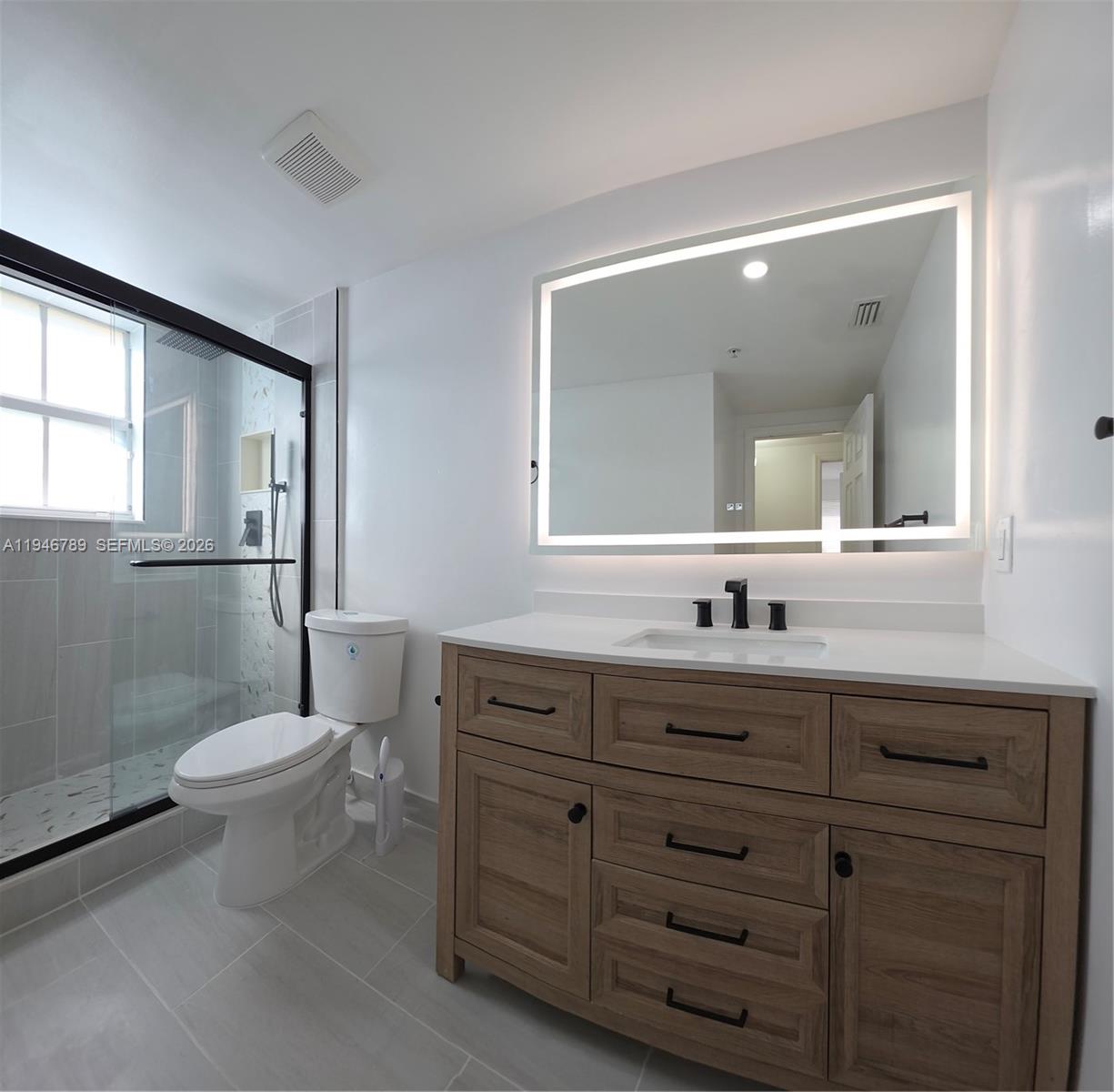 2090 West Preserve Way, Unit 301 Miramar, FL 33025 - Photo 7 of 21 a bathroom with a toilet a sink and mirror