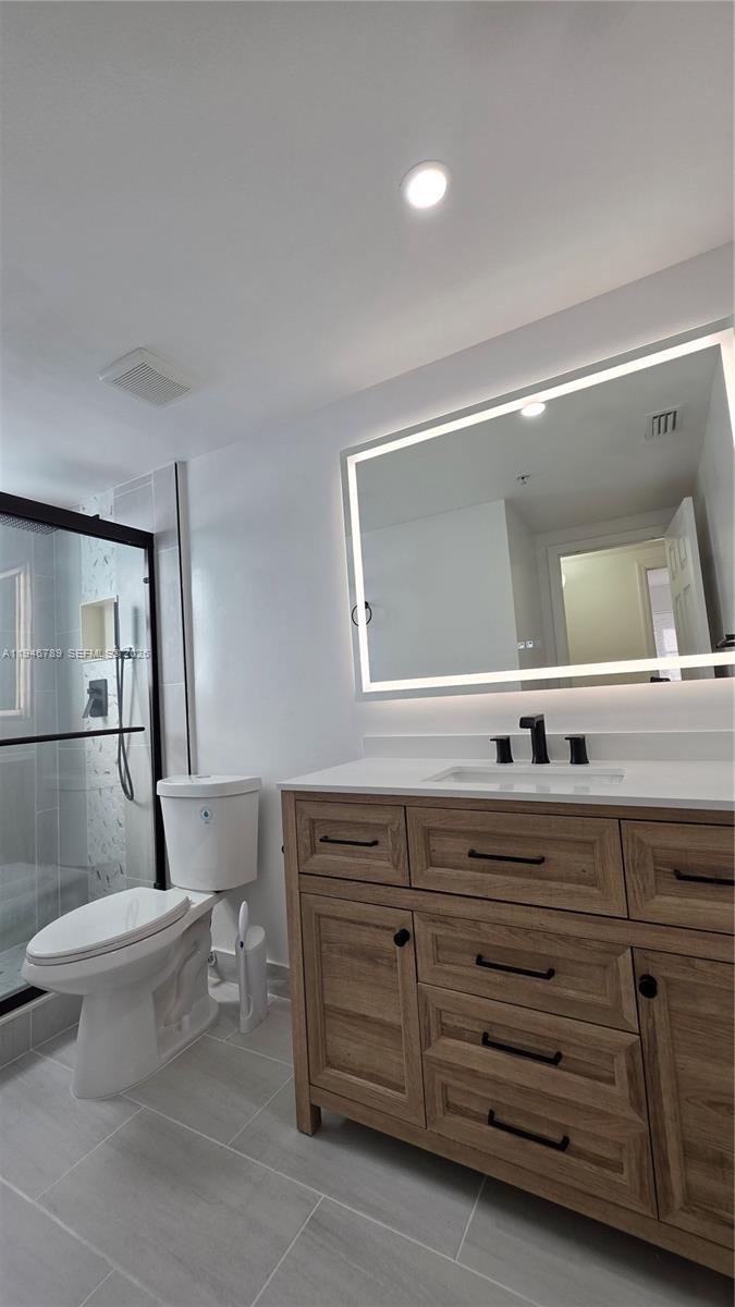 2090 West Preserve Way, Unit 301 Miramar, FL 33025 - Photo 8 of 21 a bathroom with a toilet a double vanity sink and a mirror