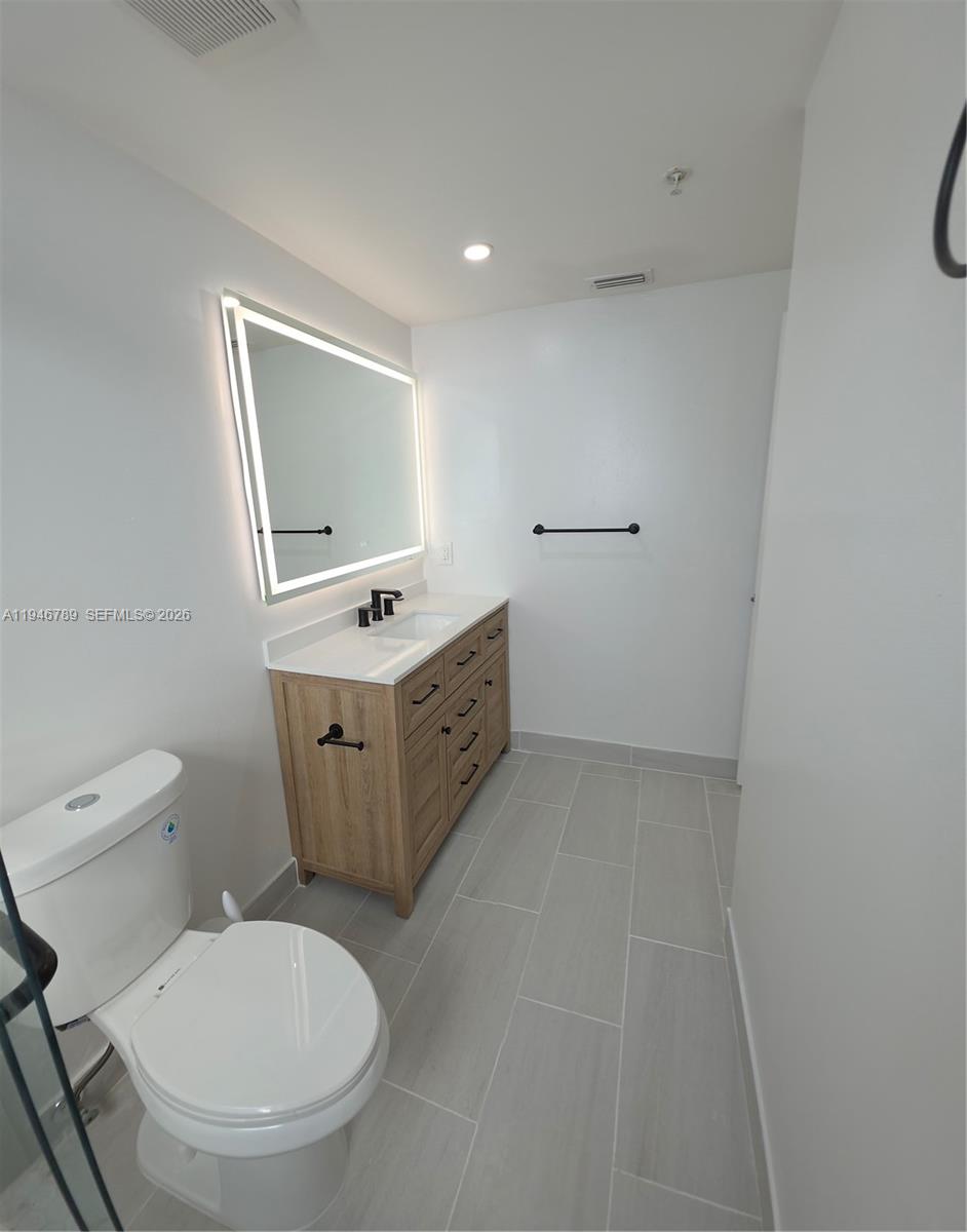 2090 West Preserve Way, Unit 301 Miramar, FL 33025 - Photo 9 of 21 a bathroom with a toilet sink and mirror