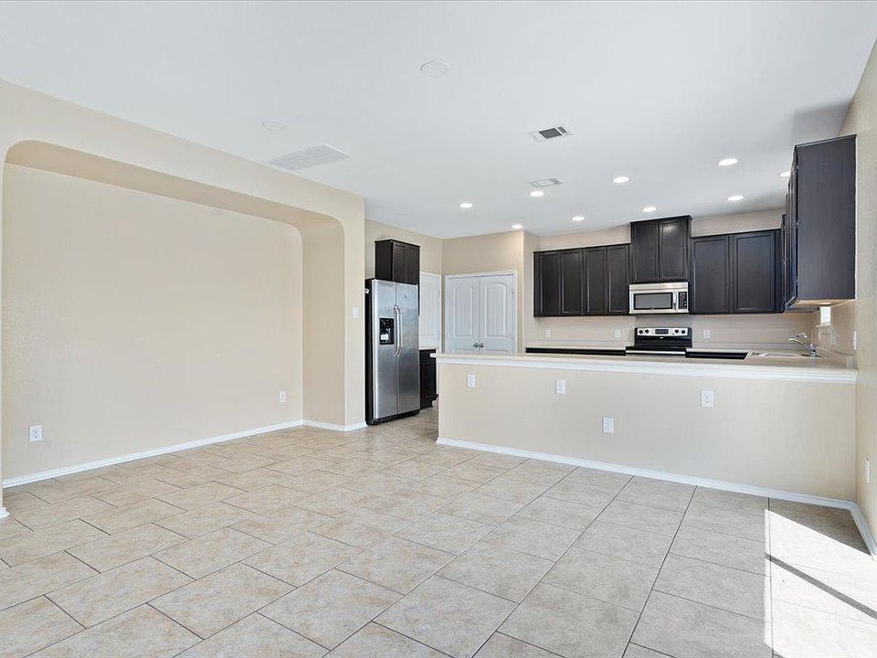 904 Lonesome Lilly Way Pflugerville, TX 78660 - Photo 13 of 34 The kitchen features dark cabinetry, stainless steel appliances, and recessed lighting