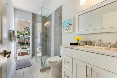 a bathroom with a granite countertop sink mirror vanity and toilet