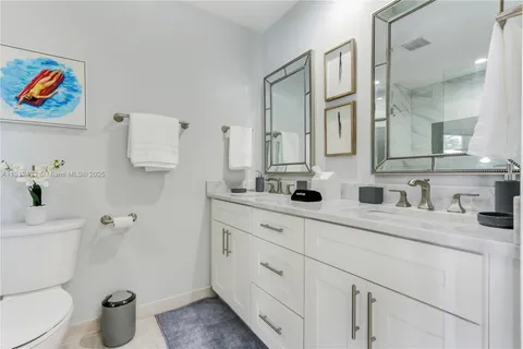 a bathroom with a granite countertop sink mirror and toilet