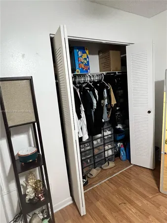 a view of walk in closet with clothes and shoes