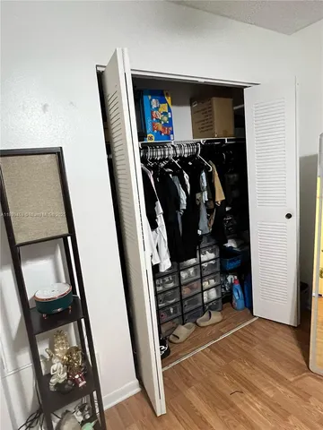 a view of walk in closet with clothes and shoes