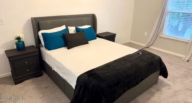 a bedroom with a bed and a window