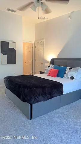 a bedroom with a large bed and a chandelier