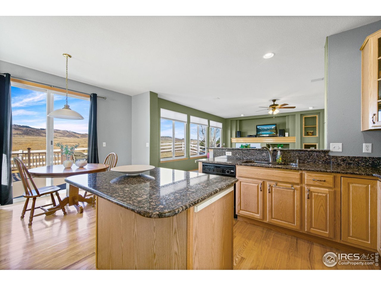 7133 Ranger Drive Fort Collins, CO 80526 - Photo 15 of 33 a kitchen with center island wooden floor and a view of living room