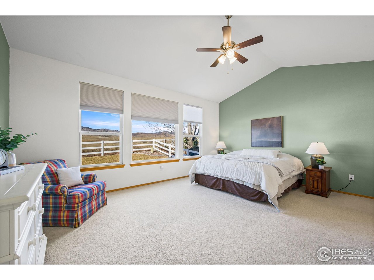 7133 Ranger Drive Fort Collins, CO 80526 - Photo 16 of 33 a spacious bedroom with a bed a couch and a chandelier