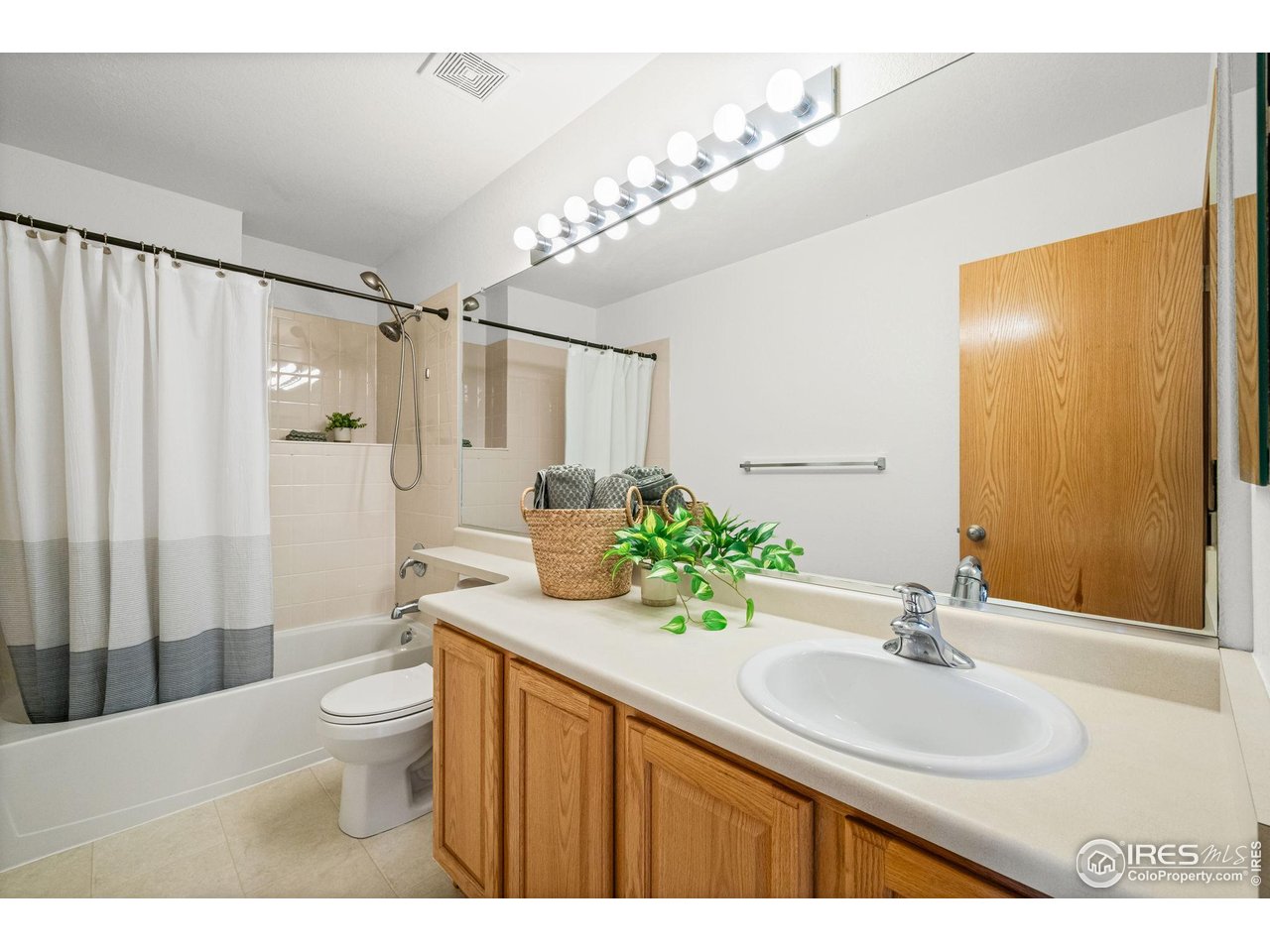 7133 Ranger Drive Fort Collins, CO 80526 - Photo 25 of 33 a bathroom with a granite countertop sink a toilet a mirror a vanity and shower