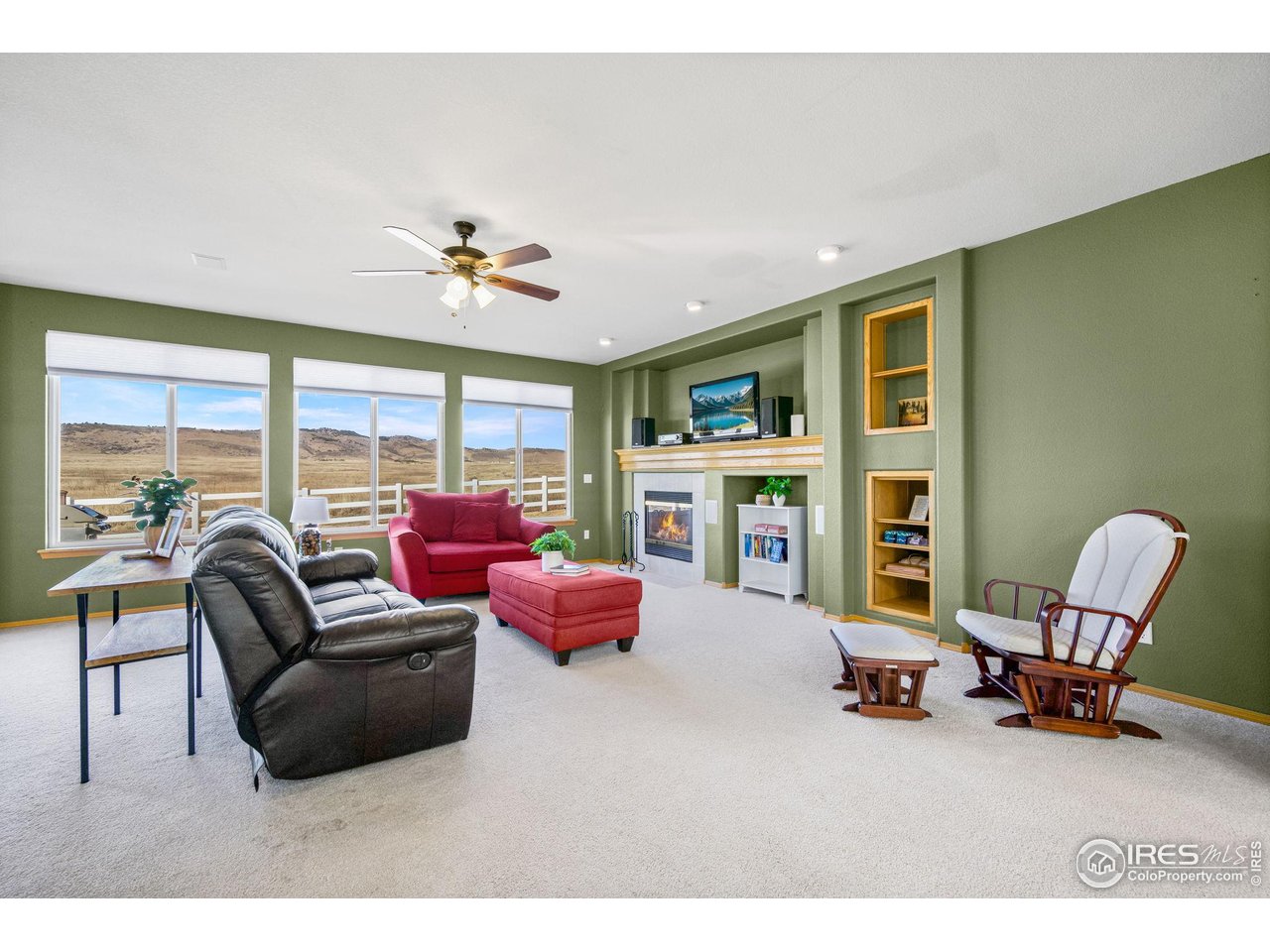 7133 Ranger Drive Fort Collins, CO 80526 - Photo 10 of 33 a living room with furniture a fireplace and a large window