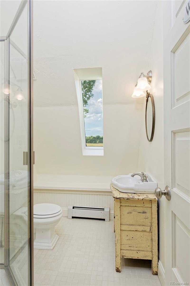 5875 Monarch Road Longmont, CO 80503 - Photo 25 of 38 a bathroom with a granite countertop sink a toilet and a shower