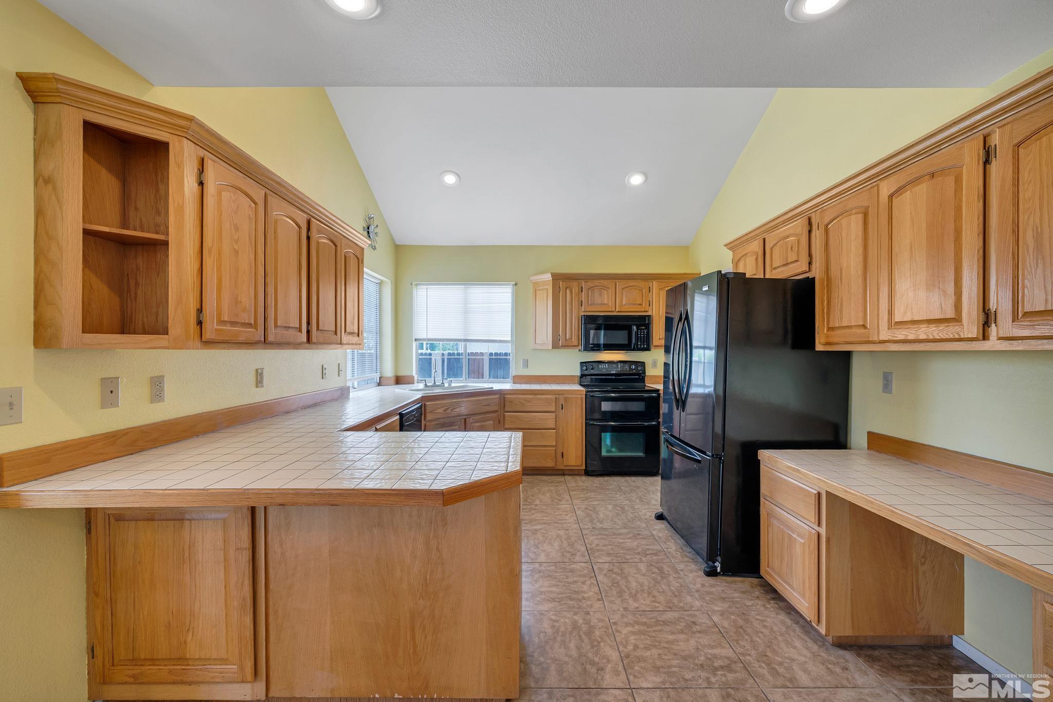 610 Sunset Drive Fallon, NV 89406 - Photo 14 of 36 a kitchen with stainless steel appliances granite countertop a sink refrigerator and microwave