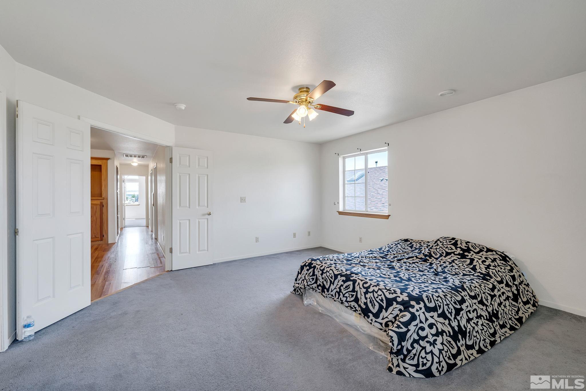 610 Sunset Drive Fallon, NV 89406 - Photo 23 of 36 a bedroom with a bed and a chandelier