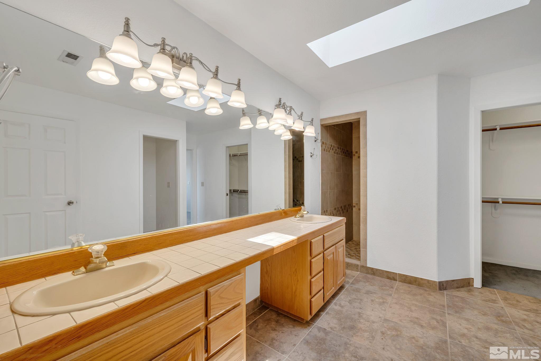 610 Sunset Drive Fallon, NV 89406 - Photo 25 of 36 a spacious bathroom with a granite countertop sink a large mirror and a shower