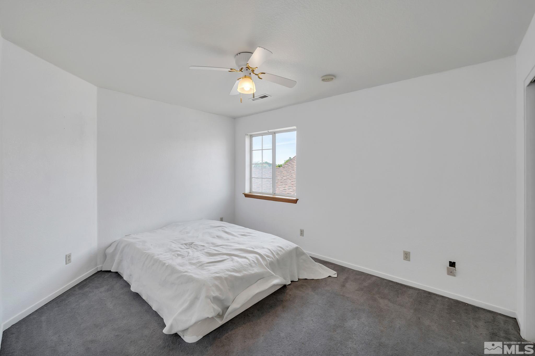 610 Sunset Drive Fallon, NV 89406 - Photo 28 of 36 a bedroom with a bed and a chandelier