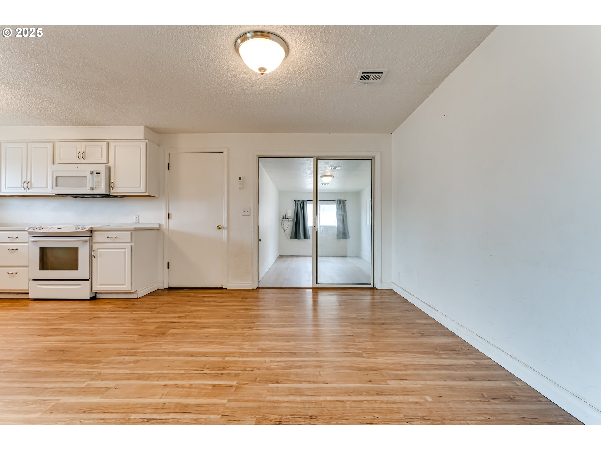 1753 10th Street Springfield, OR 97477 - Photo 13 of 35 a view of an empty room with window and wooden floor