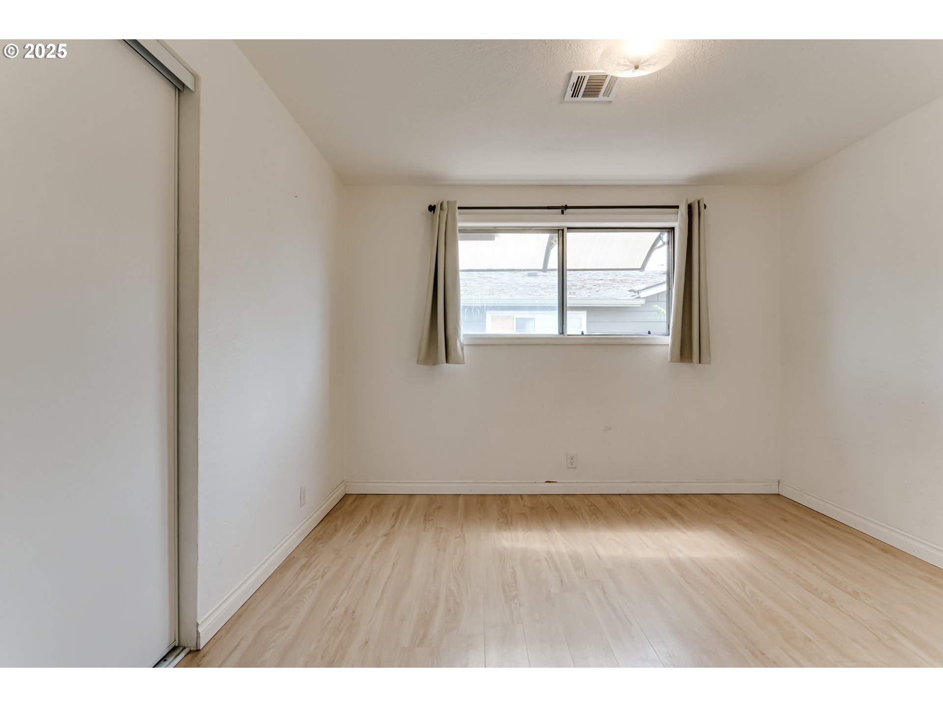 1753 10th Street Springfield, OR 97477 - Photo 21 of 35 an empty room with wooden floor and windows