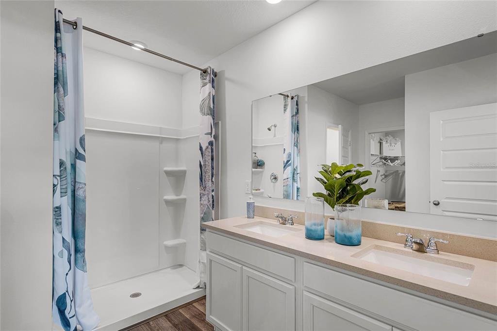 3514 Roden Road Haines City, FL 33844 - Photo 18 of 35 a bathroom with a granite countertop sink a mirror a shower and a mirror