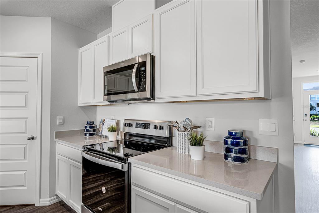 3514 Roden Road Haines City, FL 33844 - Photo 5 of 35 a kitchen with stainless steel appliances granite countertop white cabinets stove top oven and microwave