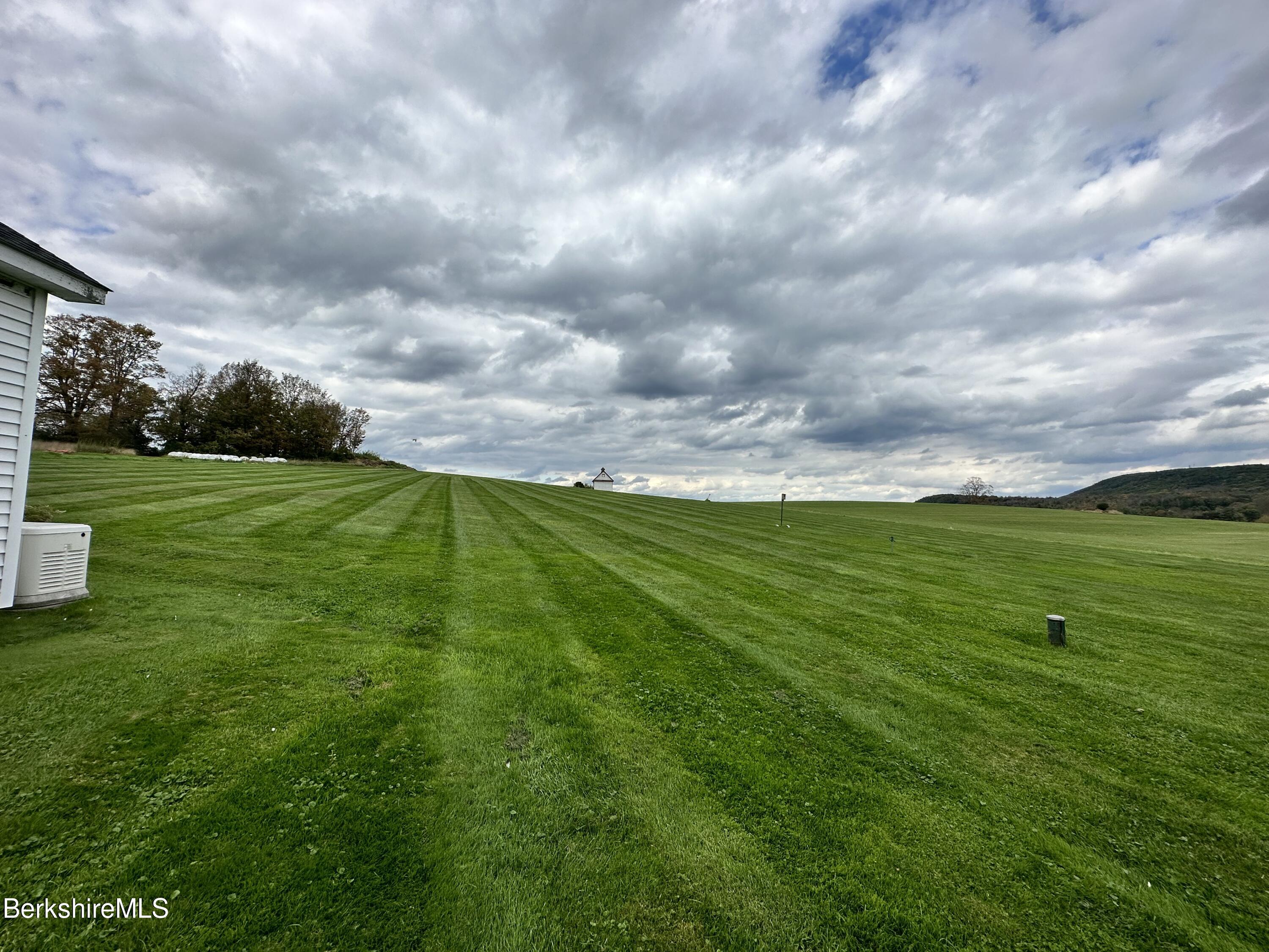 1064 E Road Richmond, MA 01254 - Photo 27 of 27 a view of a grassy field with an trees