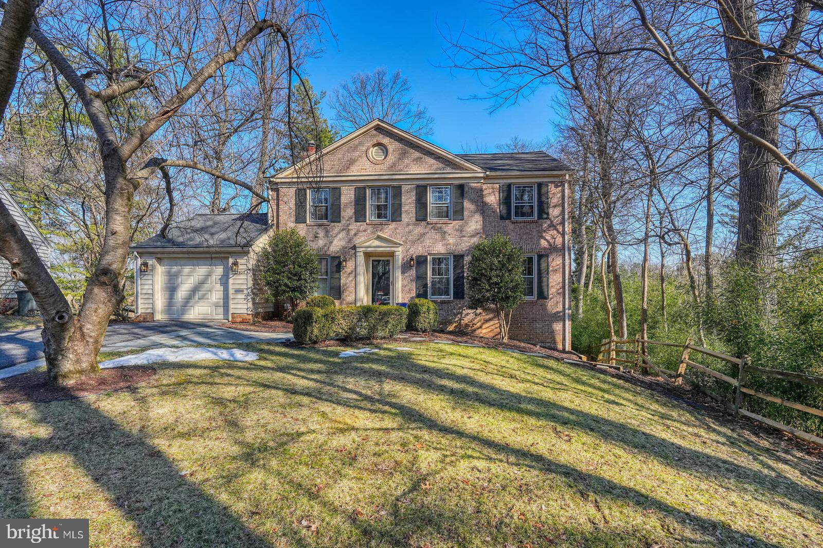 a view of a house with backyard and trees