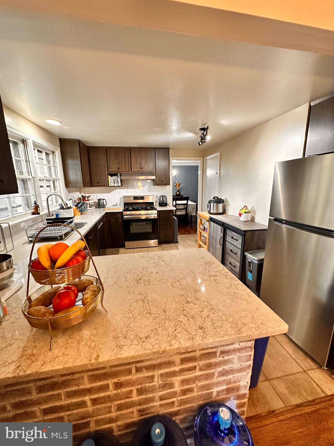 18929 Diary Road Gaithersburg, MD 20886 - Photo 37 of 52 a room with kitchen island a stove a sink dishwasher and a refrigerator with wooden floor