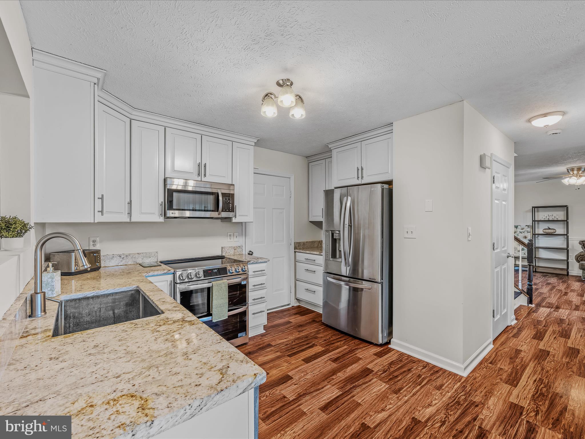571 Oak Lee Drive Ranson, WV 25438 - Photo 4 of 45 a kitchen with granite countertop a refrigerator stove and sink