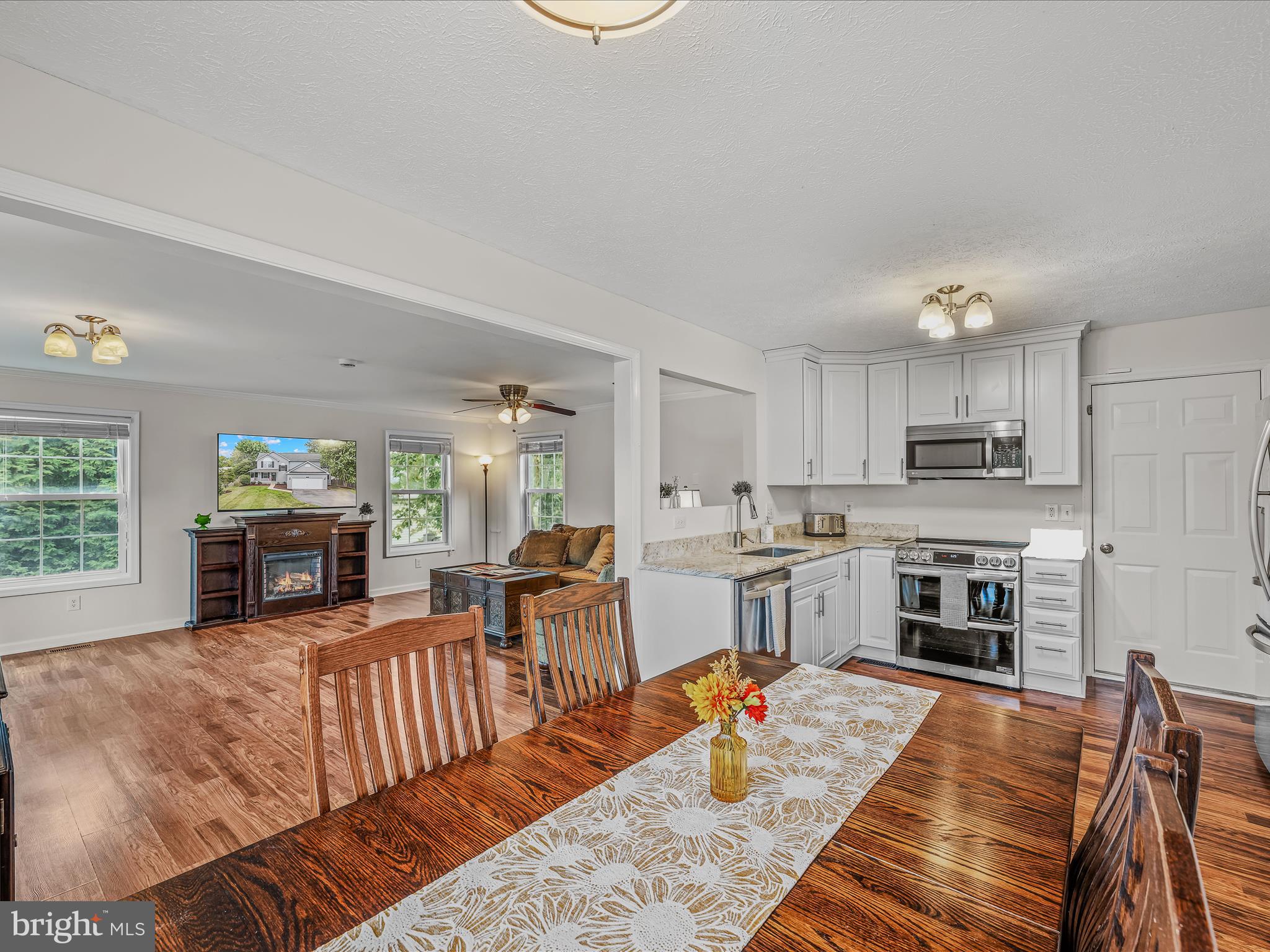 571 Oak Lee Drive Ranson, WV 25438 - Photo 7 of 45 a living room with fireplace furniture and a dining table with kitchen view