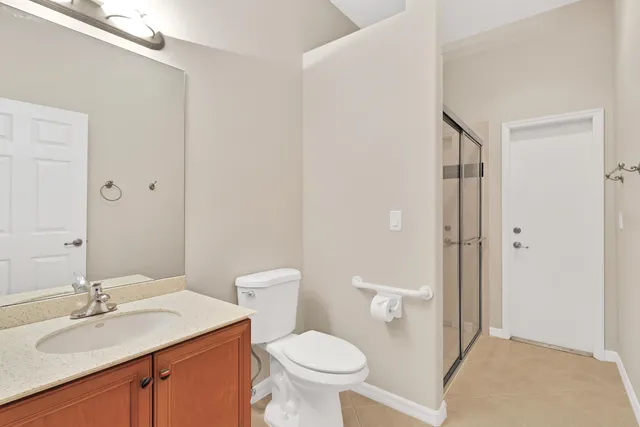 a bathroom with a granite countertop toilet a sink and a mirror