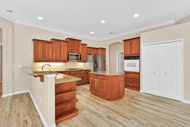 a kitchen with stainless steel appliances granite countertop a sink stove and wooden cabinets