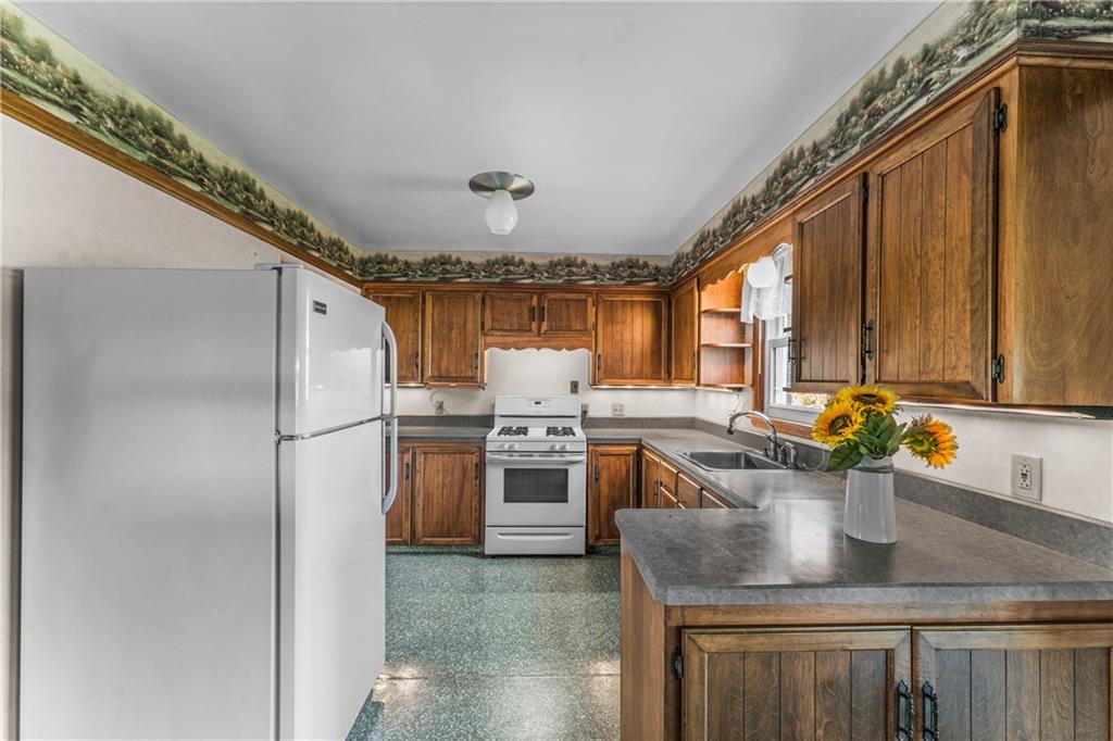 328 New Castle-Mercer Road New Wilmington, PA 16142 - Photo 8 of 26 a kitchen with stainless steel appliances granite countertop a sink a stove and a refrigerator