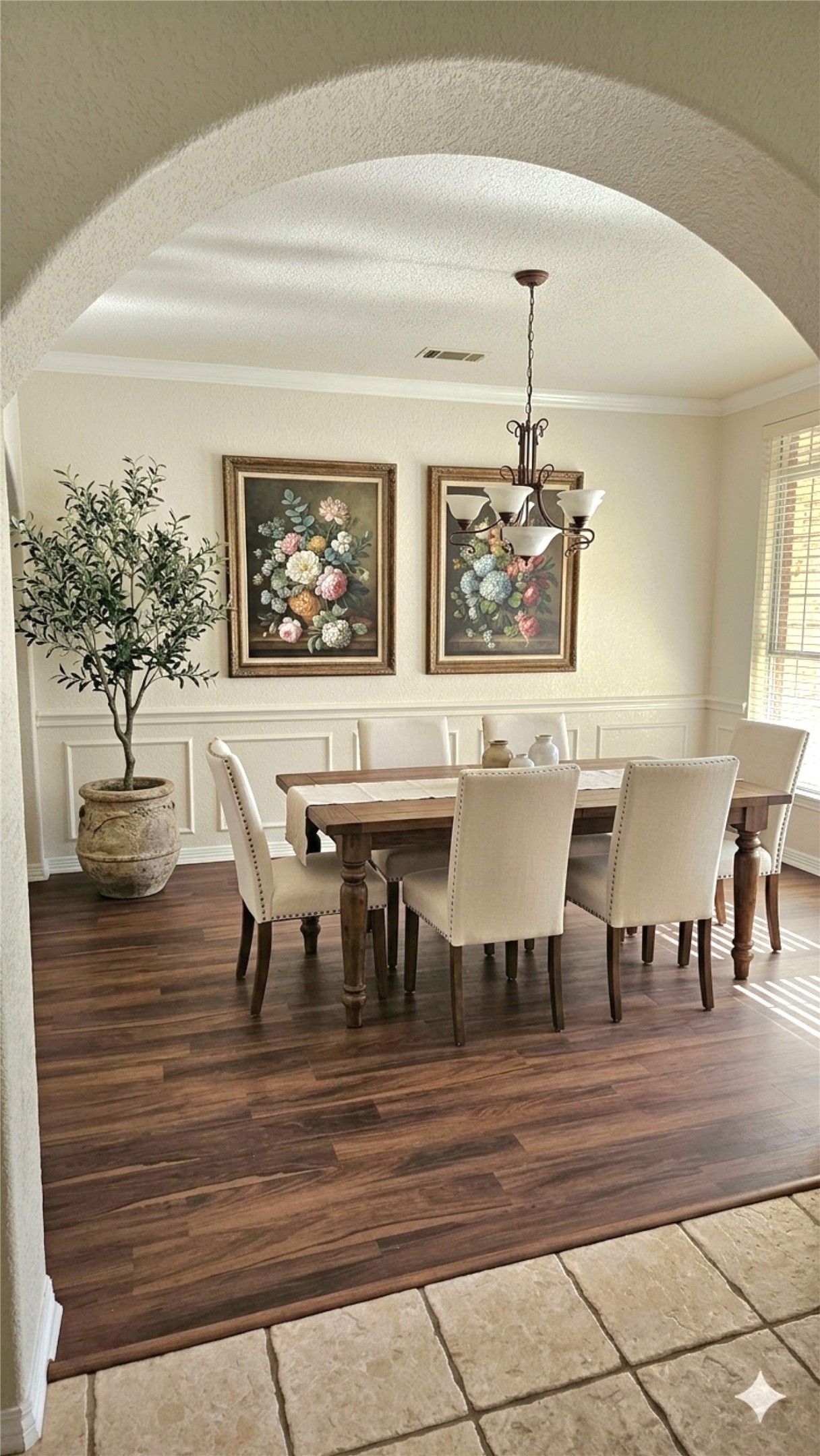 1301 County Road 262 Georgetown, TX 78633 - Photo 10 of 39 Archway entry into a dining area featuring wood-finish flooring, wainscoting, crown molding, and a traditional chandelier