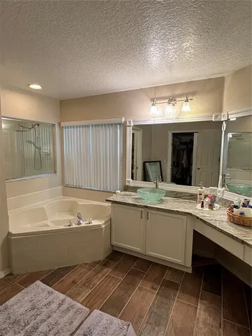 a bathroom with a tub sink and mirror