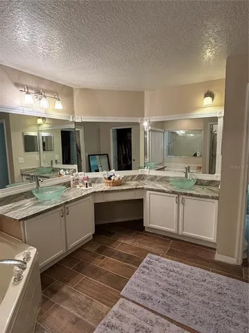 a large bathroom with a sink mirror and a bath tub
