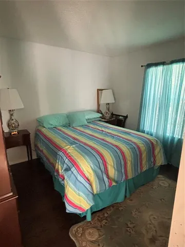 a bedroom with a bed and a lamp on dresser