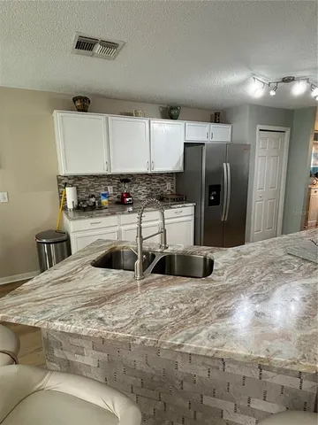 a kitchen with stainless steel appliances granite countertop a sink a stove and a refrigerator