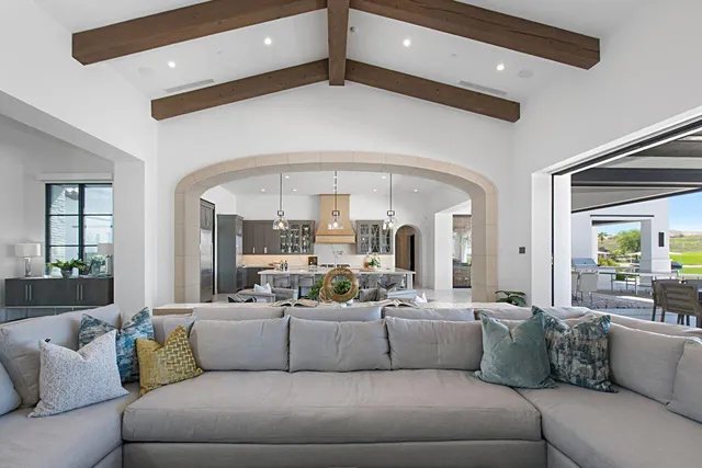 a living room with lots of furniture and kitchen view