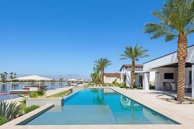 a view of a swimming pool with a lawn chairs under an umbrella