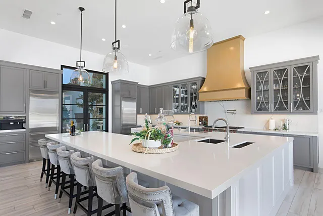 a room with kitchen island a chandelier and wooden floor