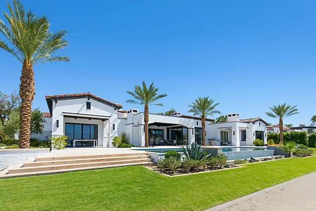 a view of a house with pool and chairs