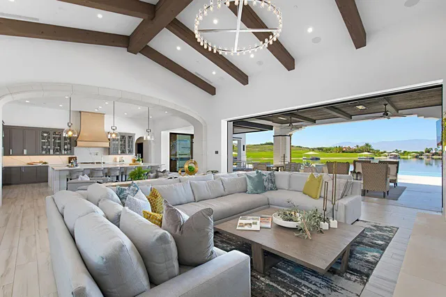 a living room with furniture kitchen view and a large window