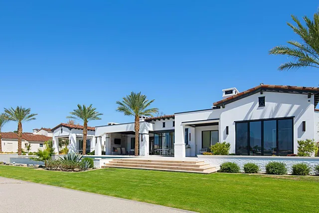 a view of a house with a swimming pool and a chairs in a patio