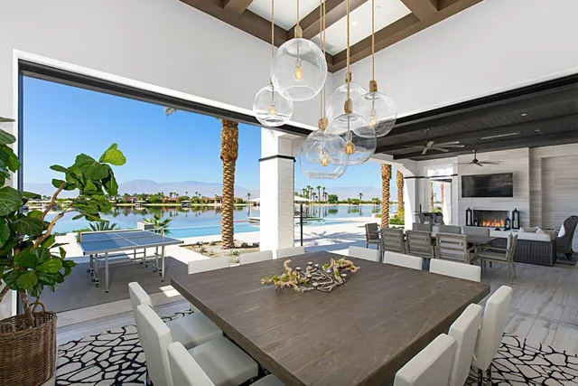 a living room with stainless steel appliances furniture a rug and white walls