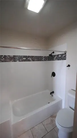 a bathroom with a bathtub and toilet