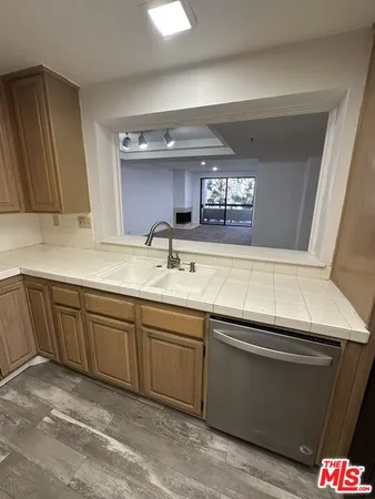 a kitchen with stainless steel appliances granite countertop a sink a stove and cabinets