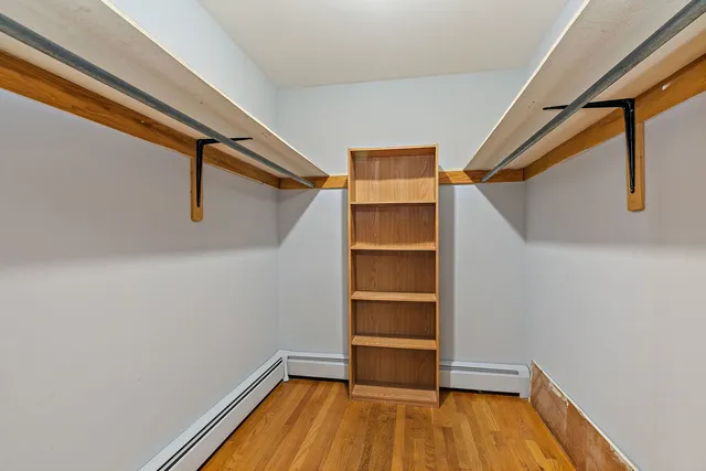 a view of walk in closet with wooden floor
