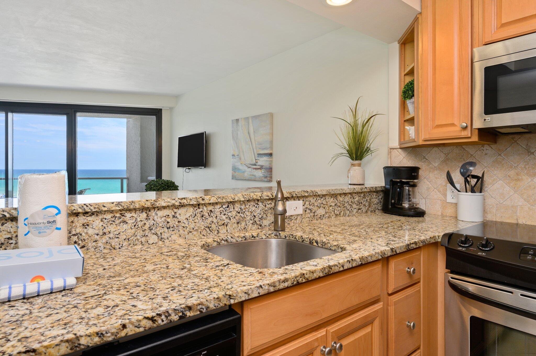 4277 Beachside 2, Unit 4277 Miramar Beach, FL 32550 - Photo 11 of 71 a kitchen with granite countertop a sink stainless steel appliances and cabinets
